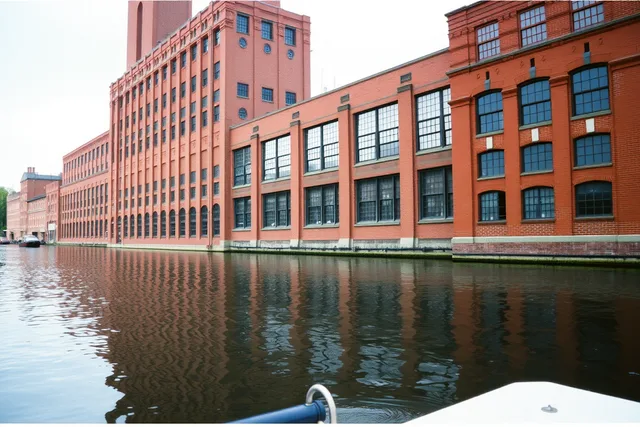Red-brick Boott Cotton Mills Museum rising above the Lowell canal. How to choose specific U.S. factory tours and industrial visits for 2027 by region